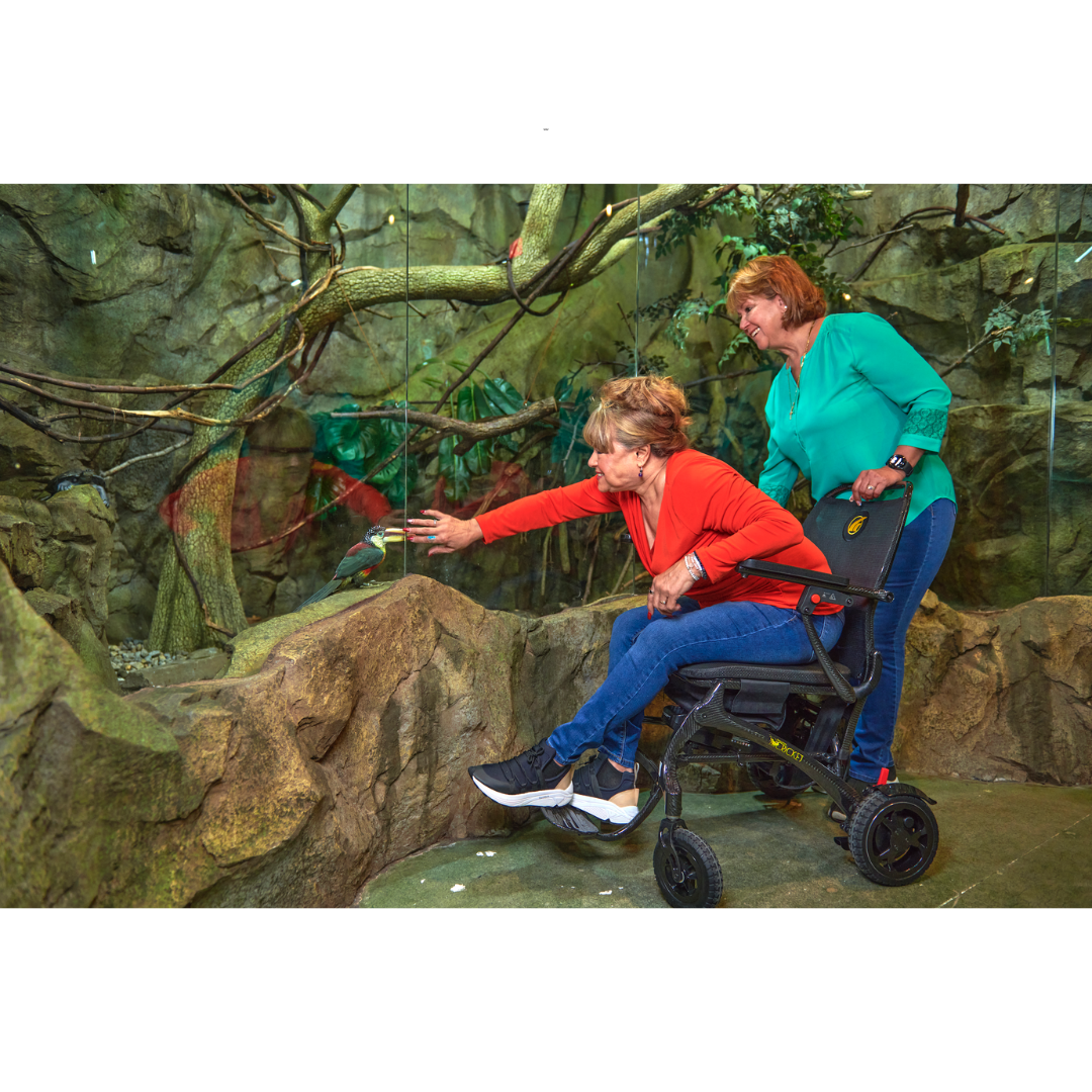Golden Tech Cricket Carbon Fiber Foldable Travel Power Wheelchair - with user operating indoor