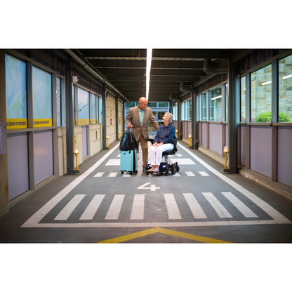 Golden Tech GP130  FAA Approved Buzzaround CarryOn Portable Power Wheelchair - with user operating on airport grounds